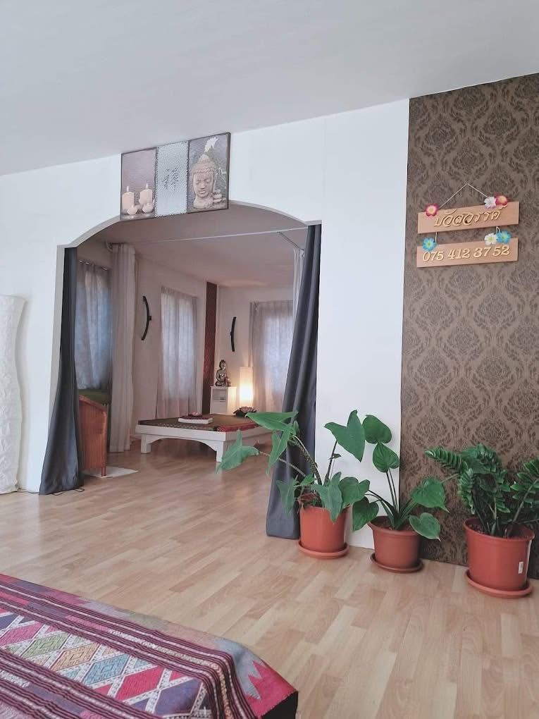 Ein Wohnzimmer mit Holzboden und Pflanzen auf dem Boden