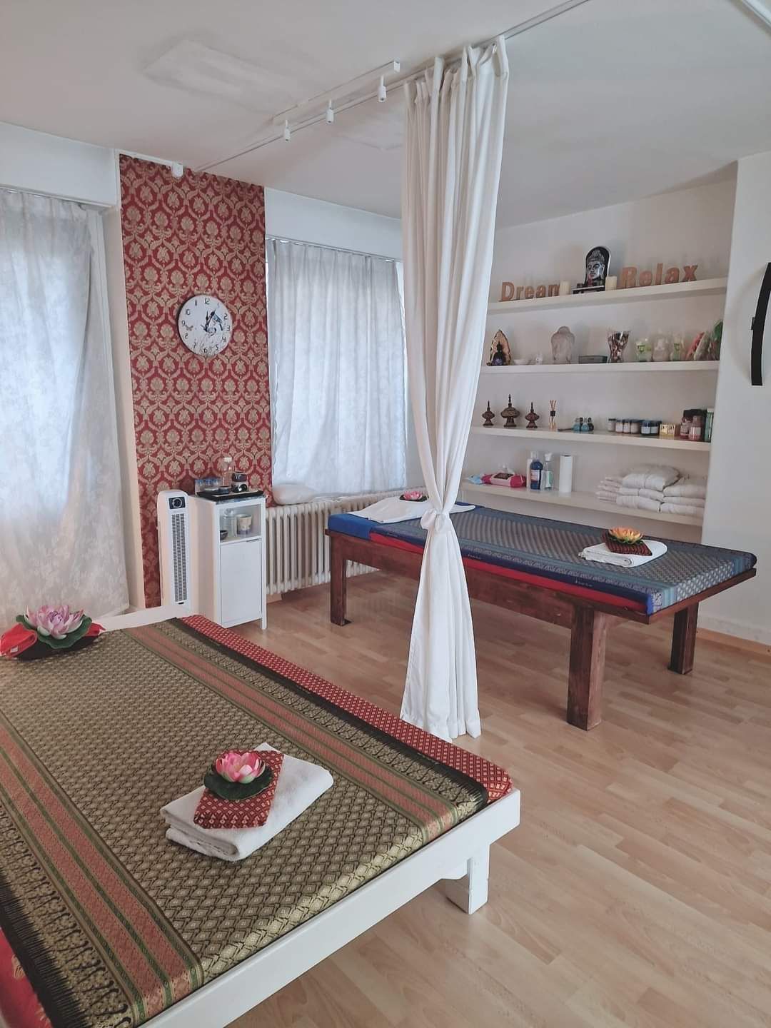 Ein Zimmer mit zwei Betten und einer Uhr an der Wand.