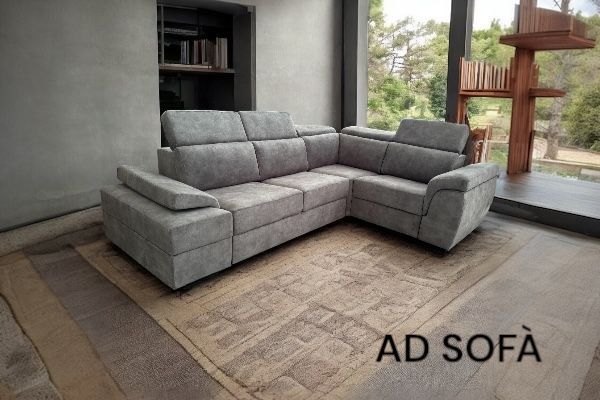 Un divano componibile grigio è appoggiato su un tappeto in soggiorno.