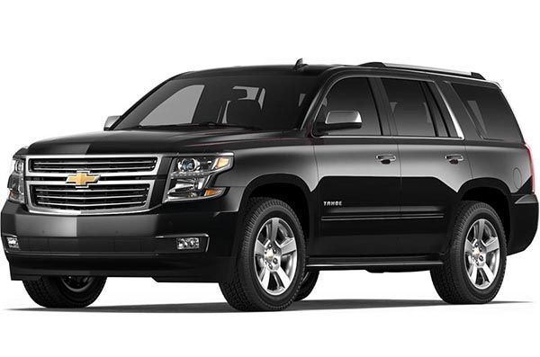 A black chevrolet tahoe suv is parked on a white background.