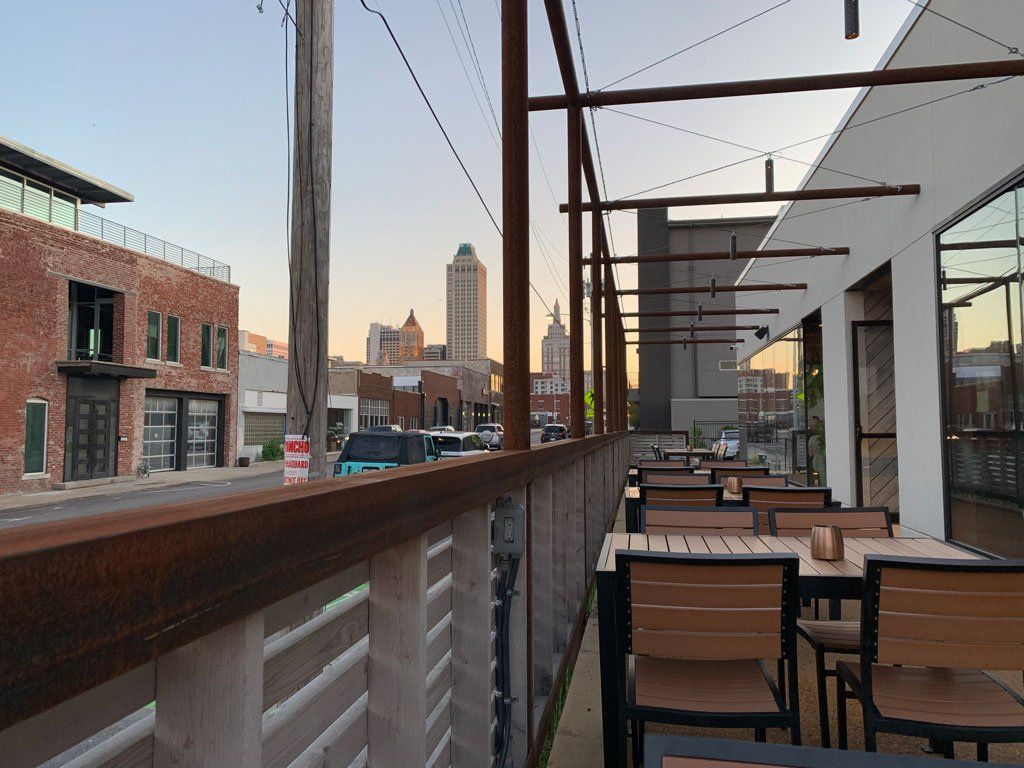 A patio with tables and chairs with a city in the background