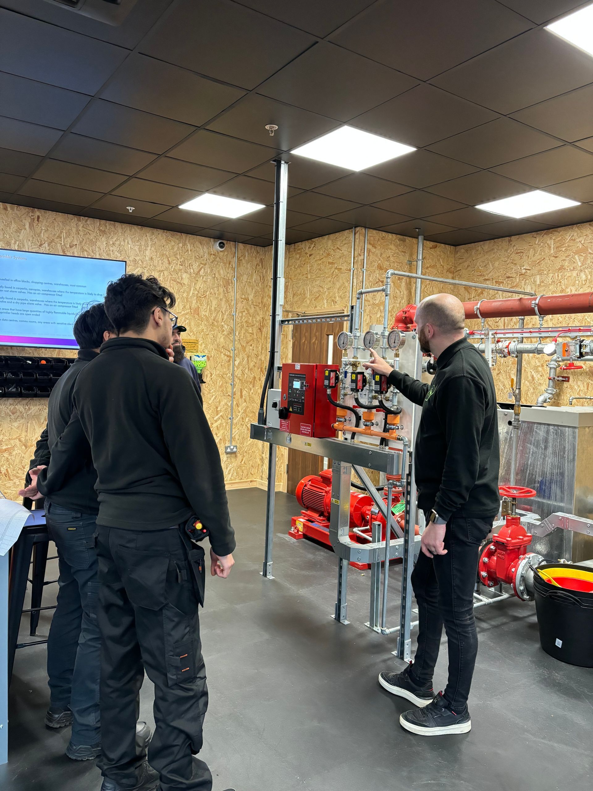 A group of men are standing in a room looking at a machine.