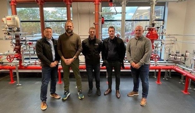 A group of men are standing next to each other in a room.