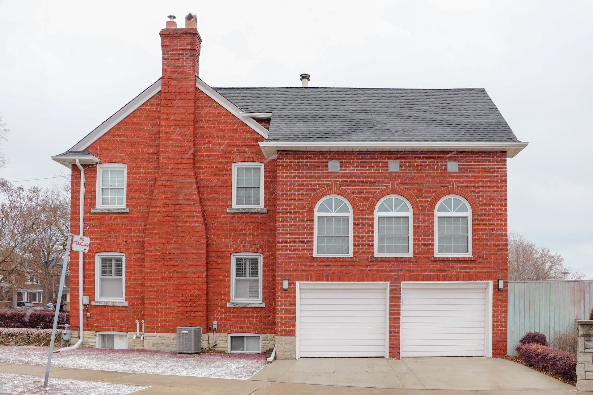 A Red Brick House With A No Parking Sign In Front Of It