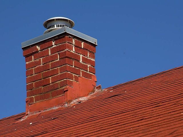A Brick Chimney Is Sitting On Top Of A Red Roof