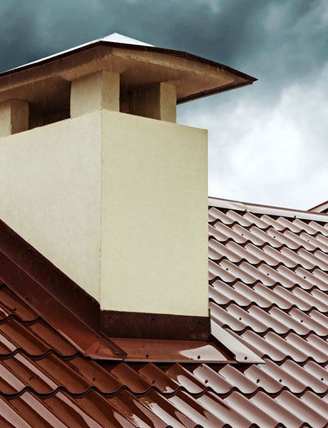 A Chimney On Top Of A Roof With A Cloudy Sky In The Background