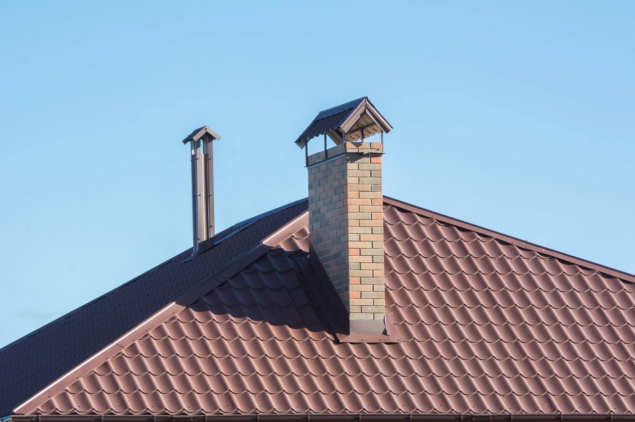 A Brick Chimney On Top Of A Brown Roof