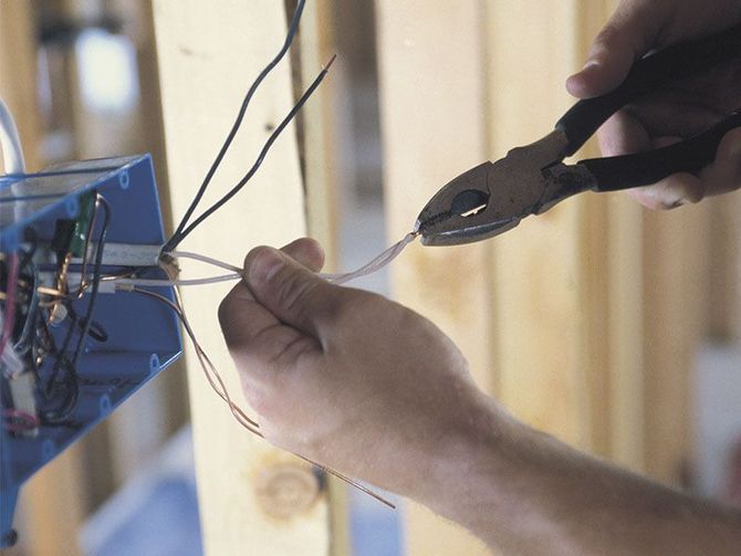 A person is cutting a wire with a pair of pliers.