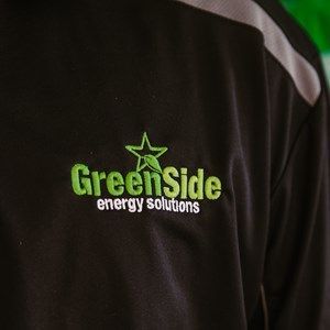 A black shirt with green side energy solutions embroidered on it