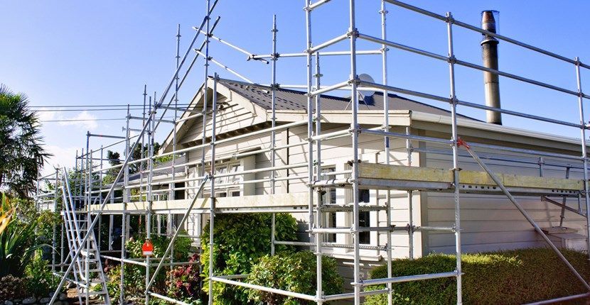 A house is being remodeled with scaffolding around it.