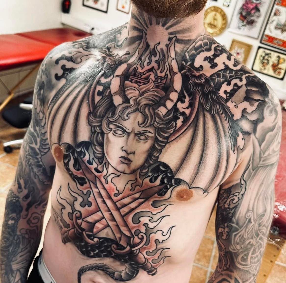 Stort bryststykke med demonisk ansikt, sverd og flammer i black & grey-stil med røde detaljer