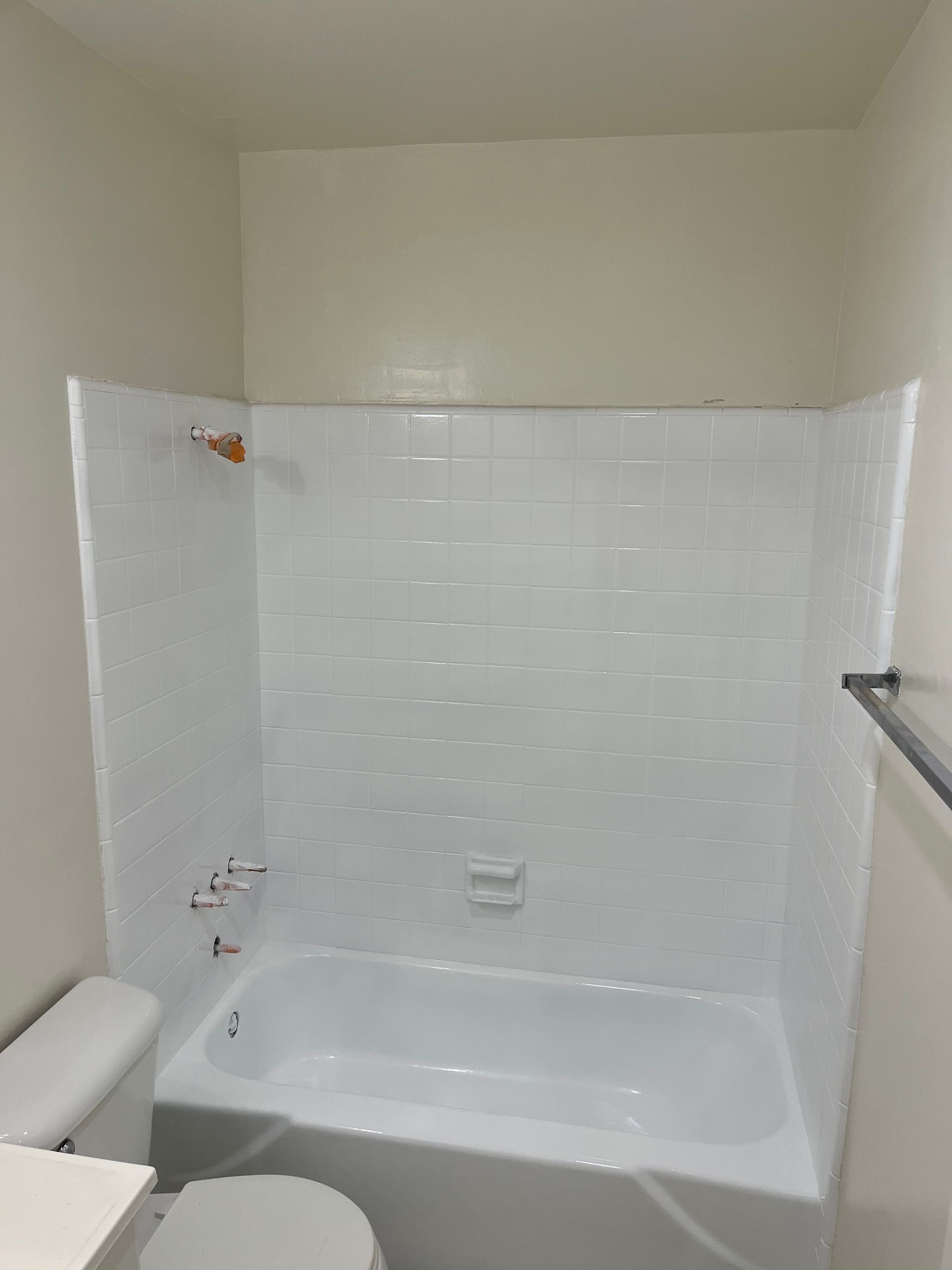 A bathroom with a bathtub , toilet and shower.