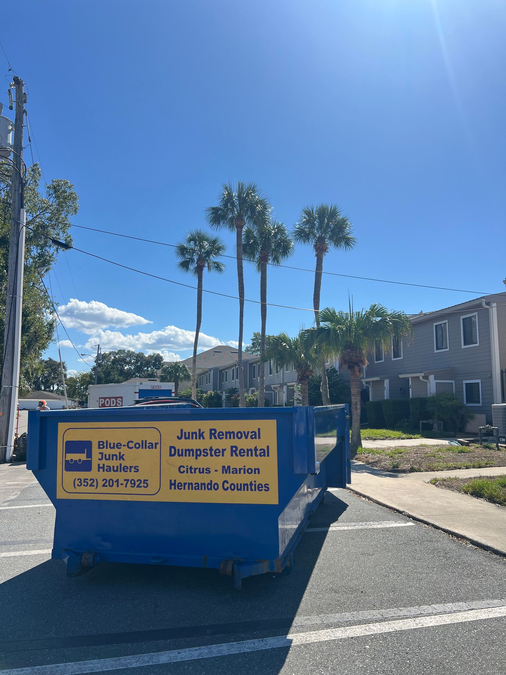 A dumpster is parked on the side of the road