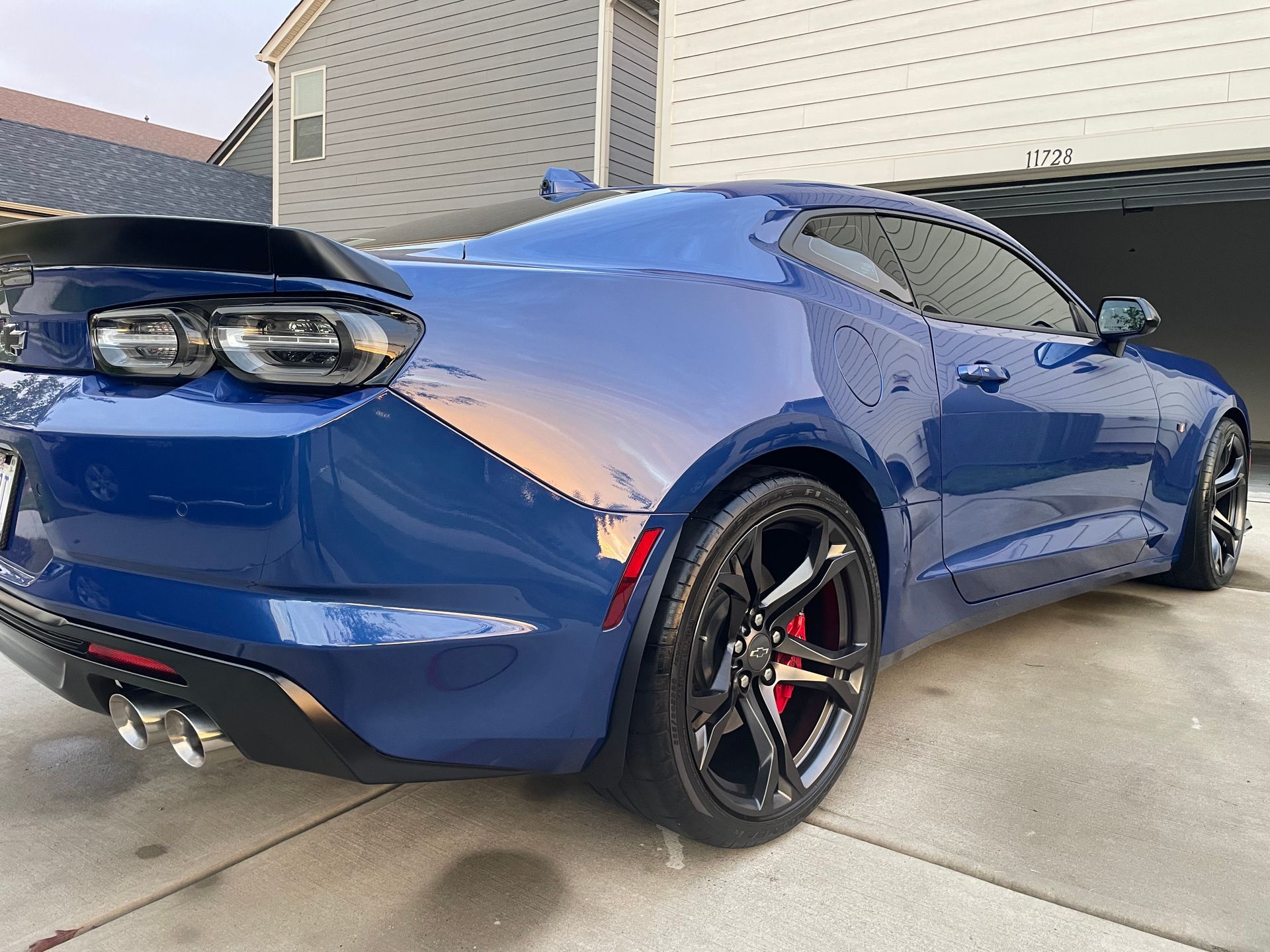 White Acura MDX SUV parked on a street with tinted windows and dark rims.