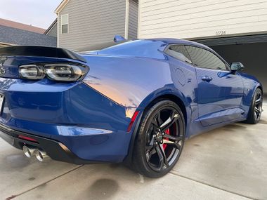 White Acura MDX SUV parked on a street with tinted windows and dark rims.