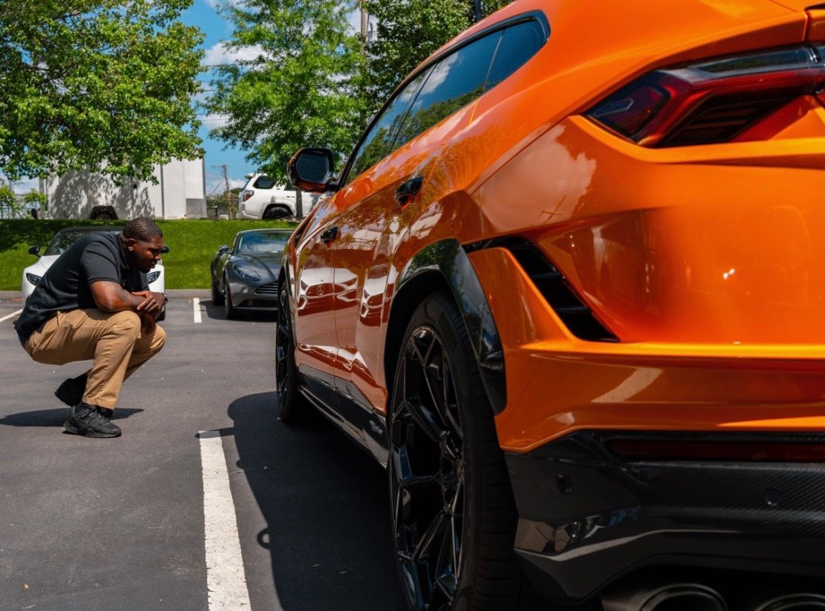 White Ford Mustang parked in front of a gray auto shop building.