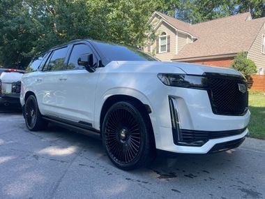 Red Ferrari sports car parked indoors, surrounded by other vehicles.