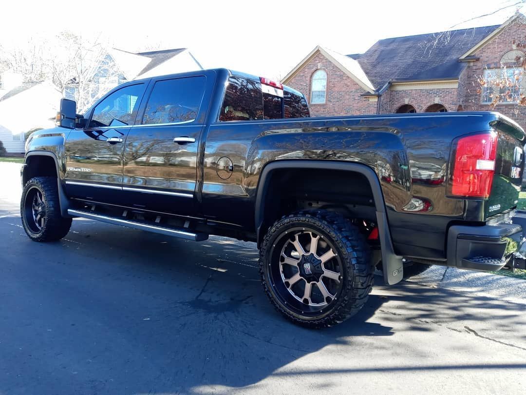 Black lifted pickup truck parked on asphalt.