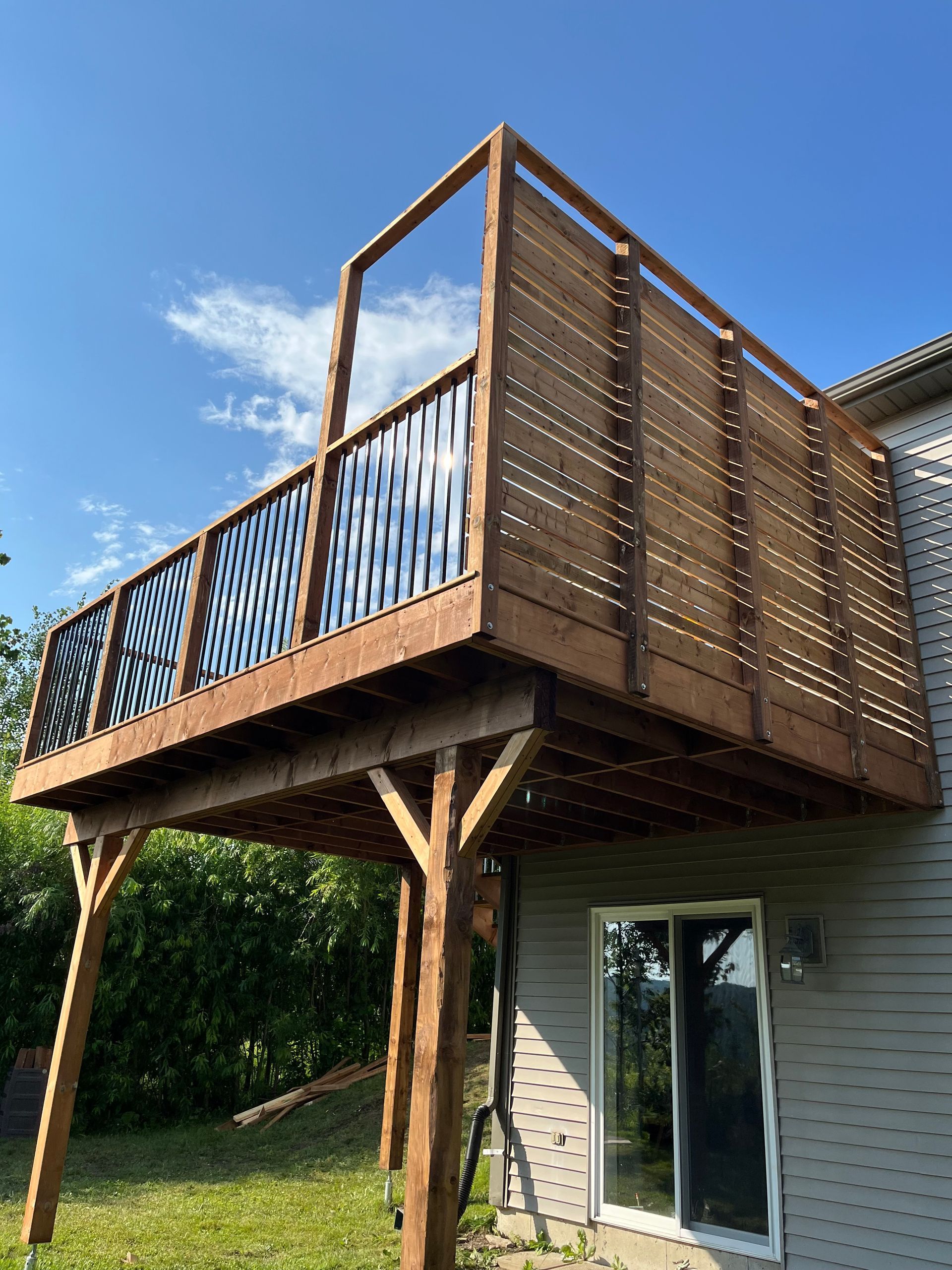Une terrasse en bois est attachée au côté d'une maison.