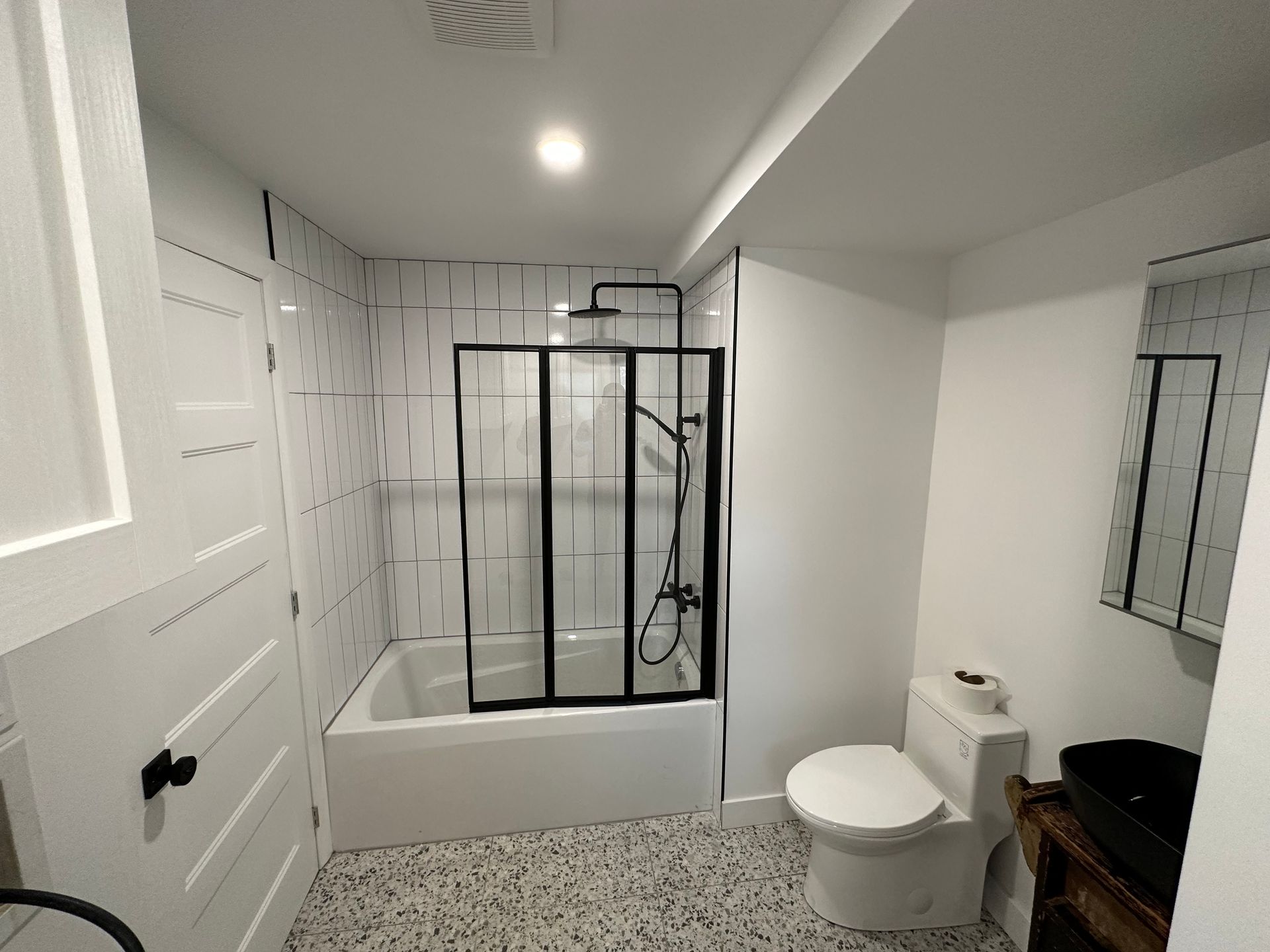 Une salle de bain avec WC, baignoire, douche et miroir.