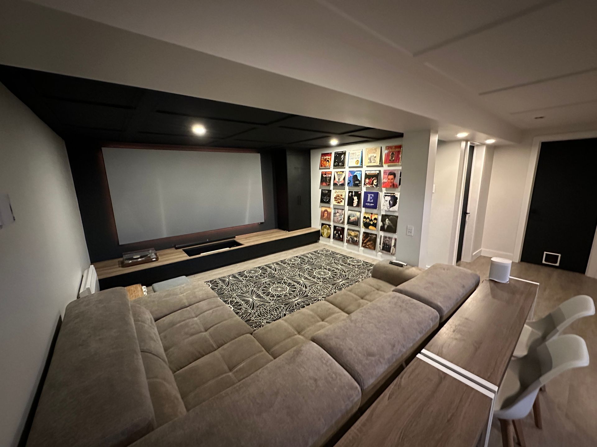 Un salon avec un canapé et un écran de projection