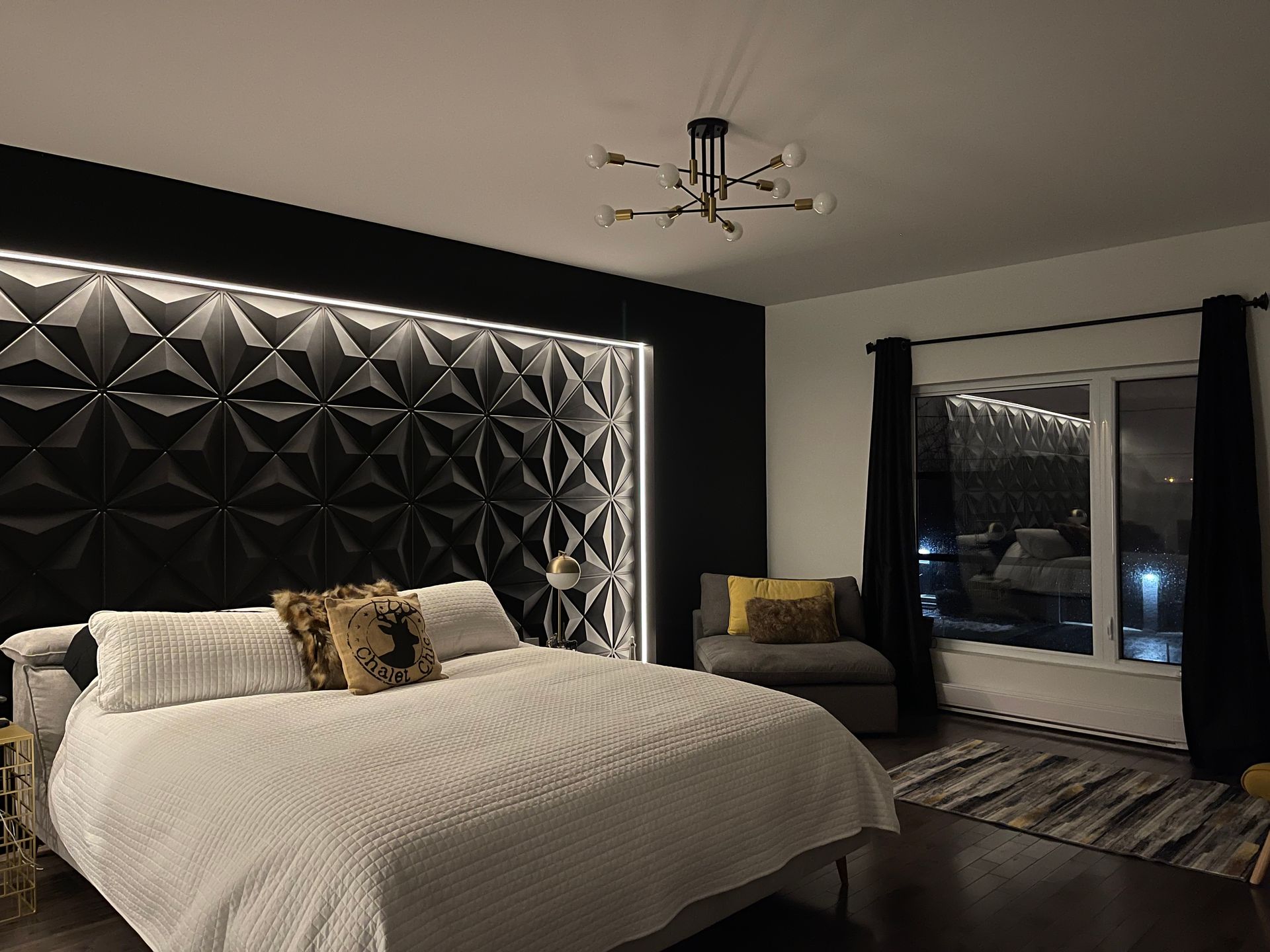 Une chambre avec un grand lit et un lustre suspendu au plafond