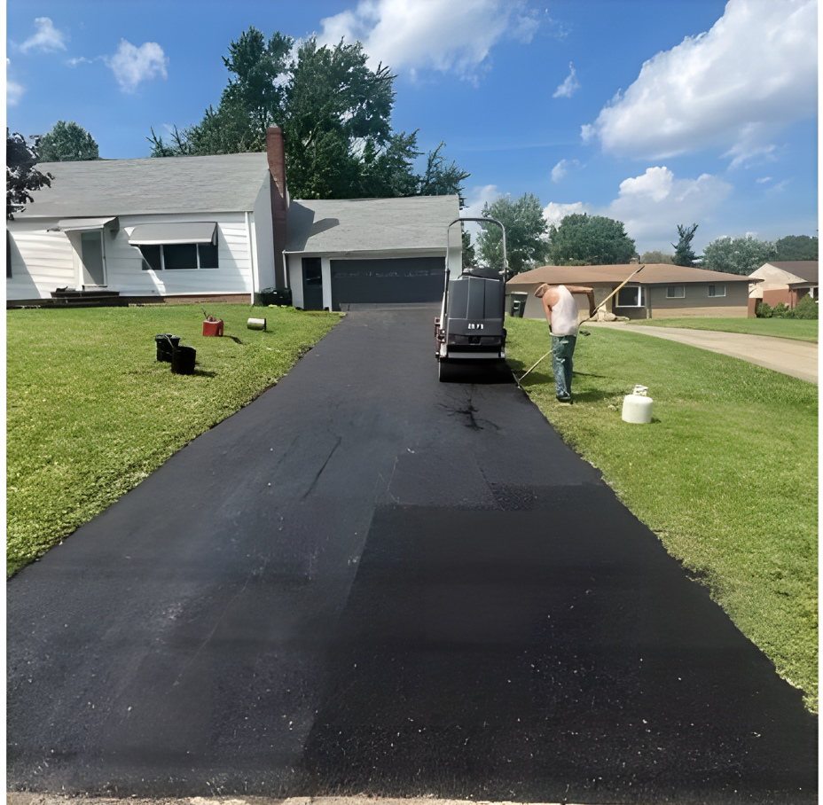 A driveway is being paved in front of a house