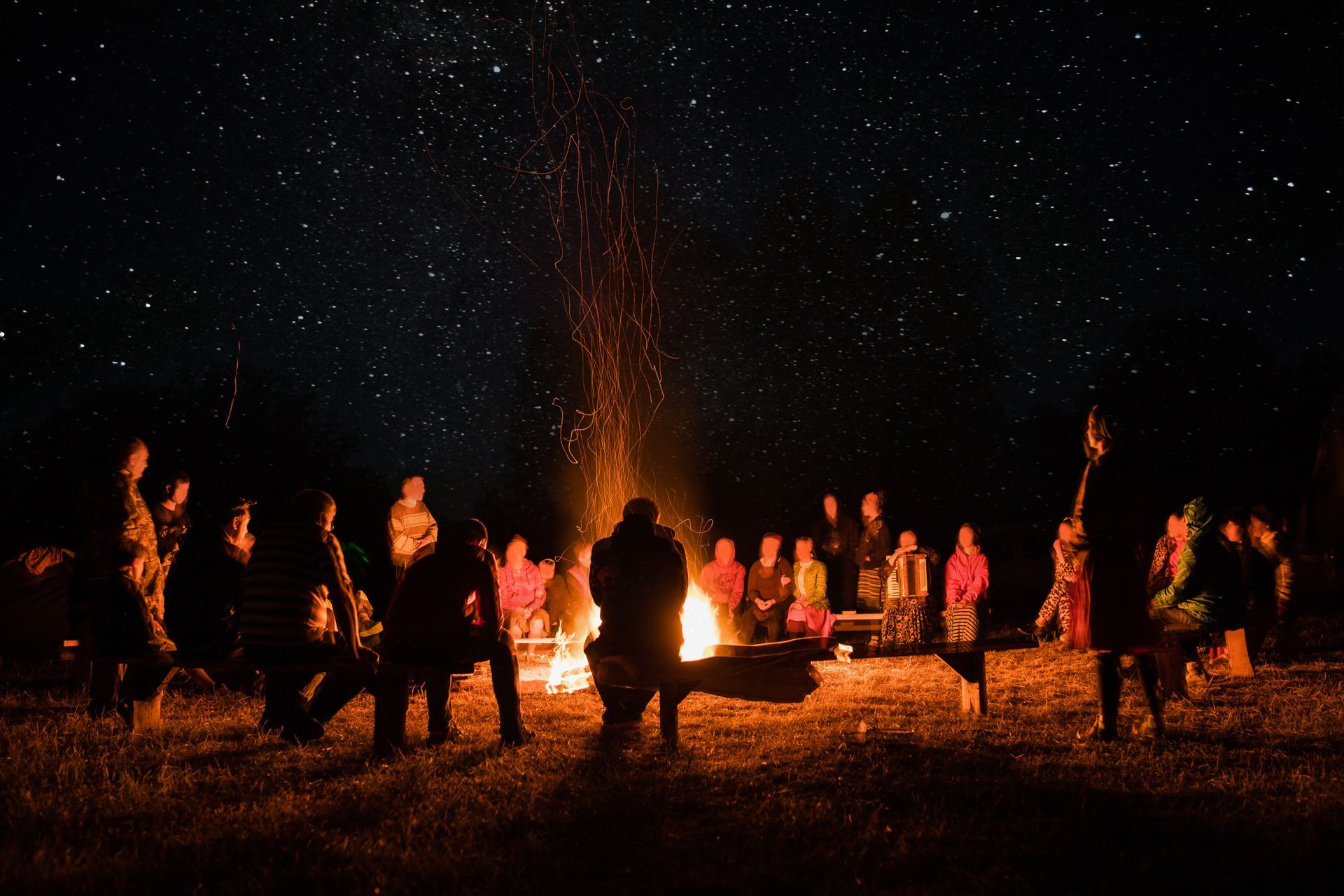 Bonfire at night with people around it