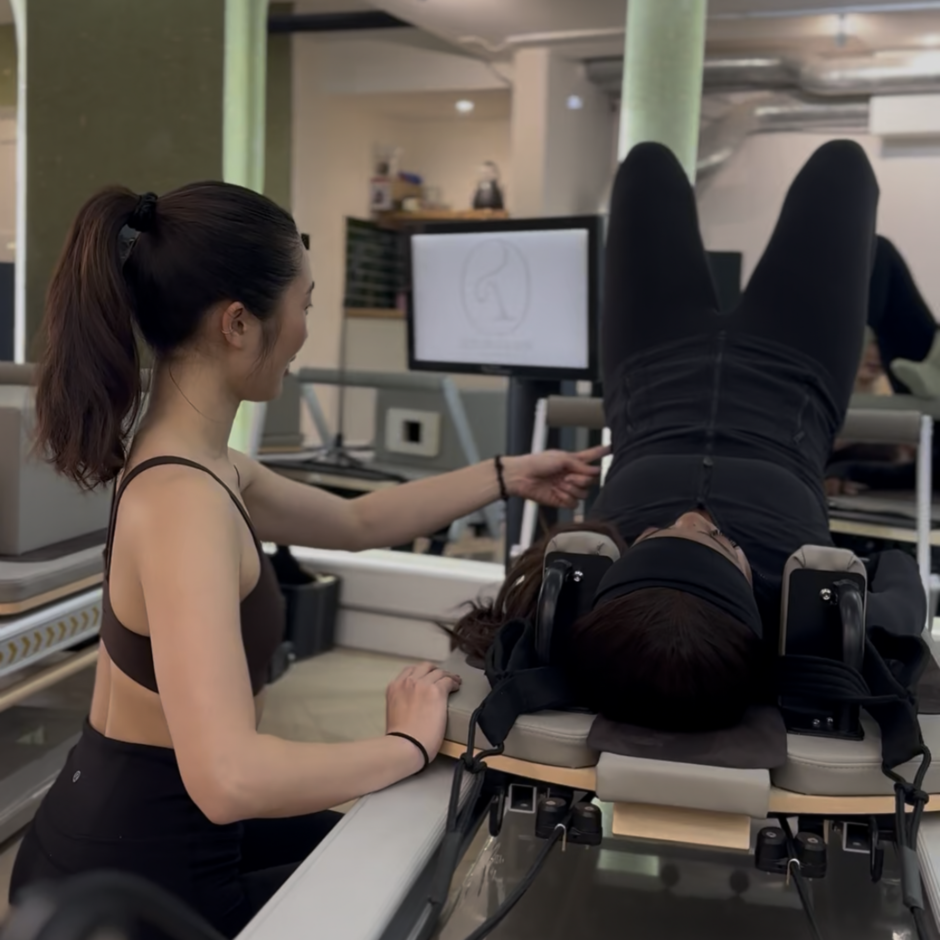 Client performing Pilates exercise in 121 session at Reform & Rise Pilates studio Roman Road East London