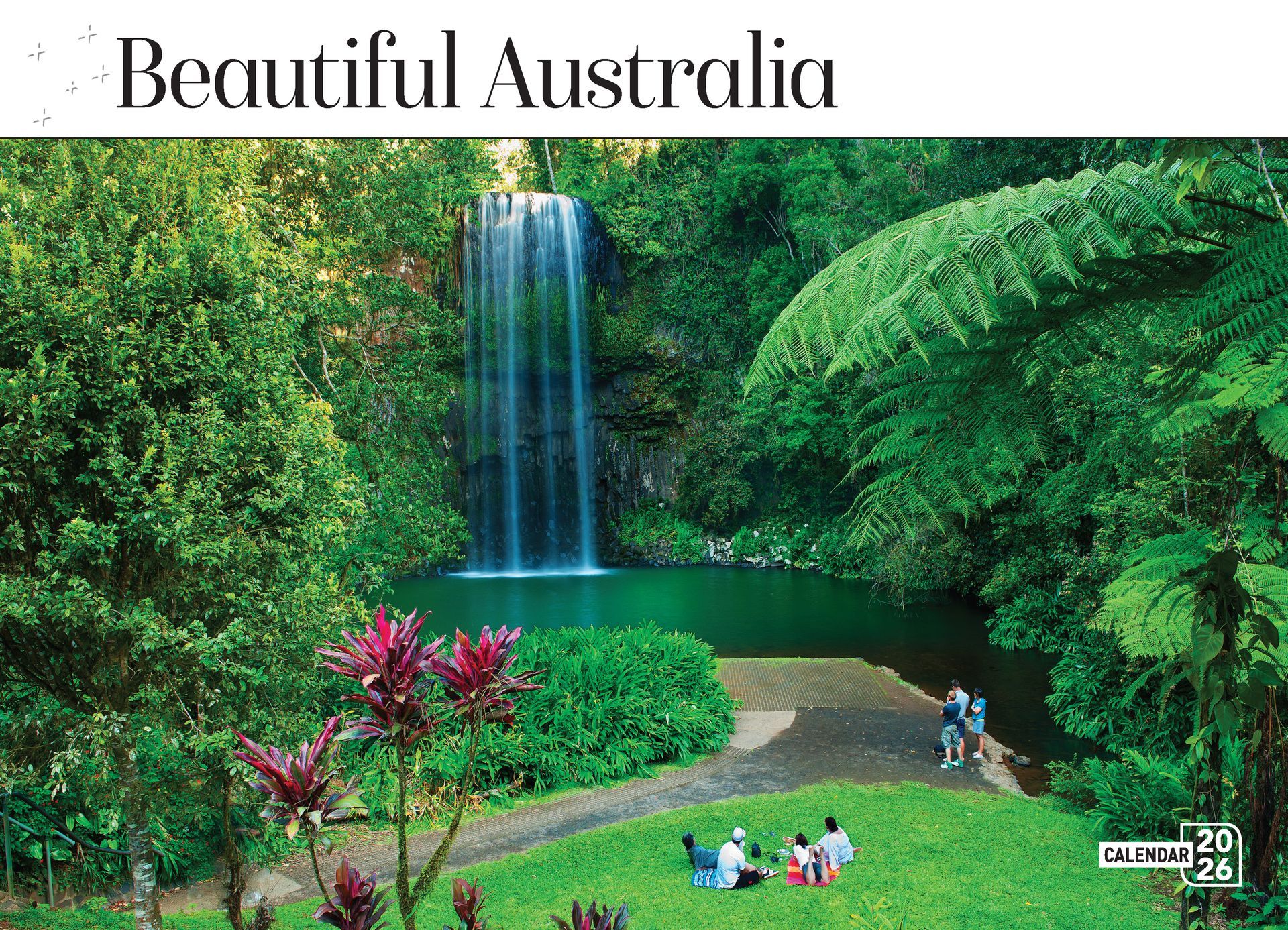 Waterfall cascading into a turquoise pool, surrounded by lush green foliage and a grassy lawn with people relaxing.