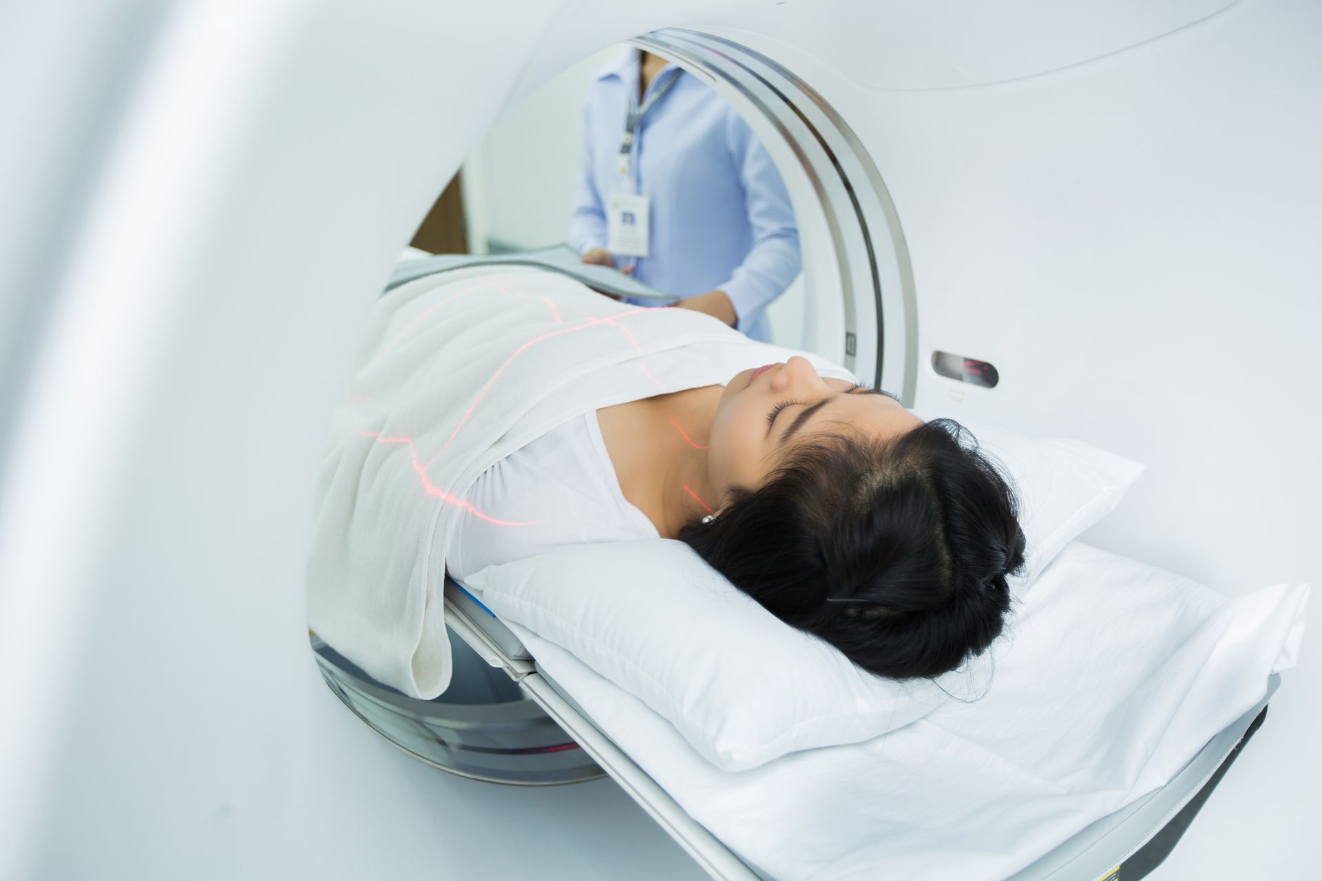 Eine Frau liegt in einem Krankenhausbett und wird einem CT-Scan unterzogen.