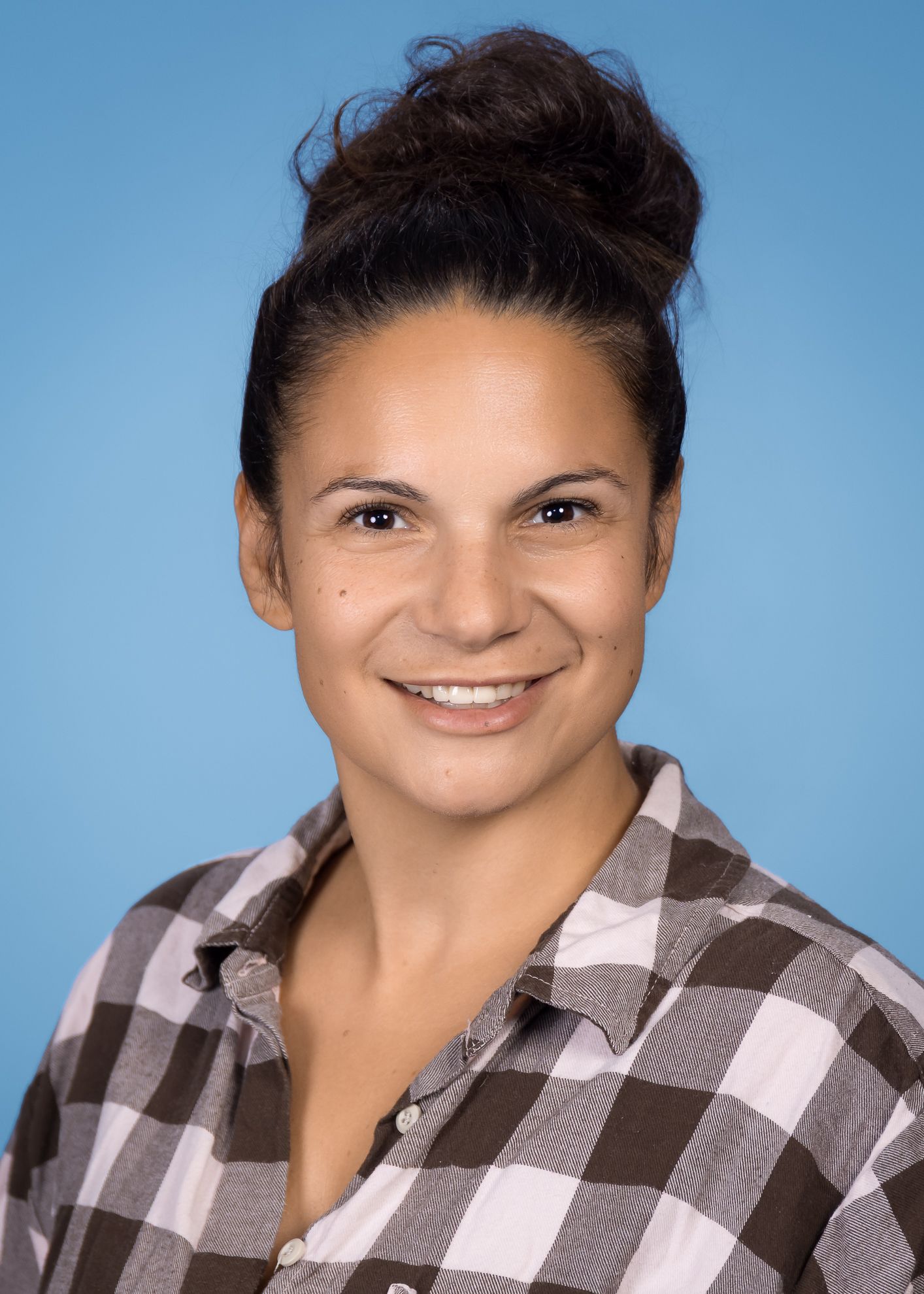 Eine Frau mit blondem Haar trägt ein schwarzes Hemd und lächelt in die Kamera.