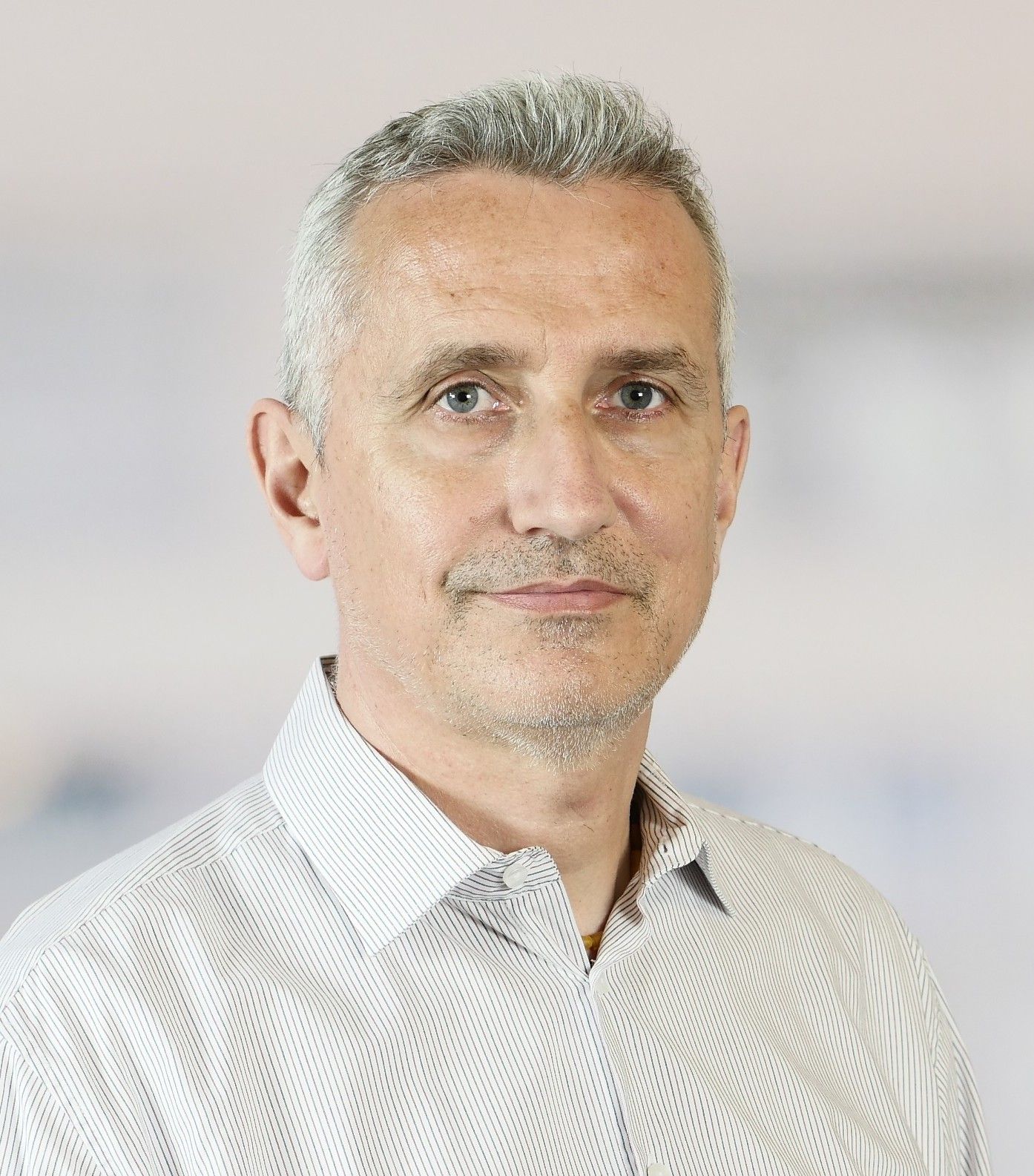 Eine Frau mit Brille und schwarzem Hemd lächelt in die Kamera.