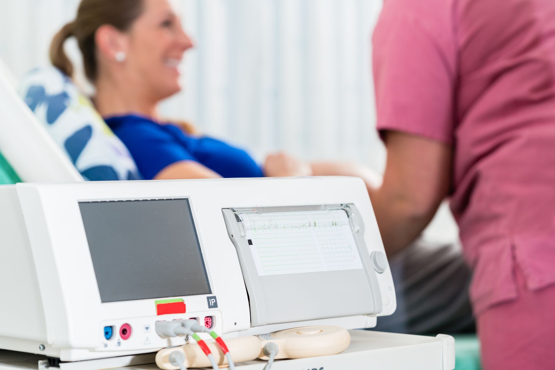 Eine Frau liegt in einem Krankenhausbett neben einer Maschine.