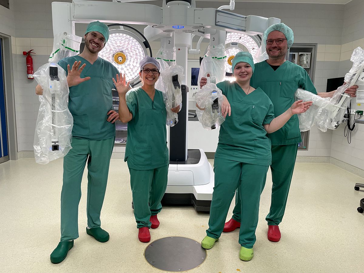 Eine Gruppe von Chirurgen posiert in einem Operationssaal für ein Foto.