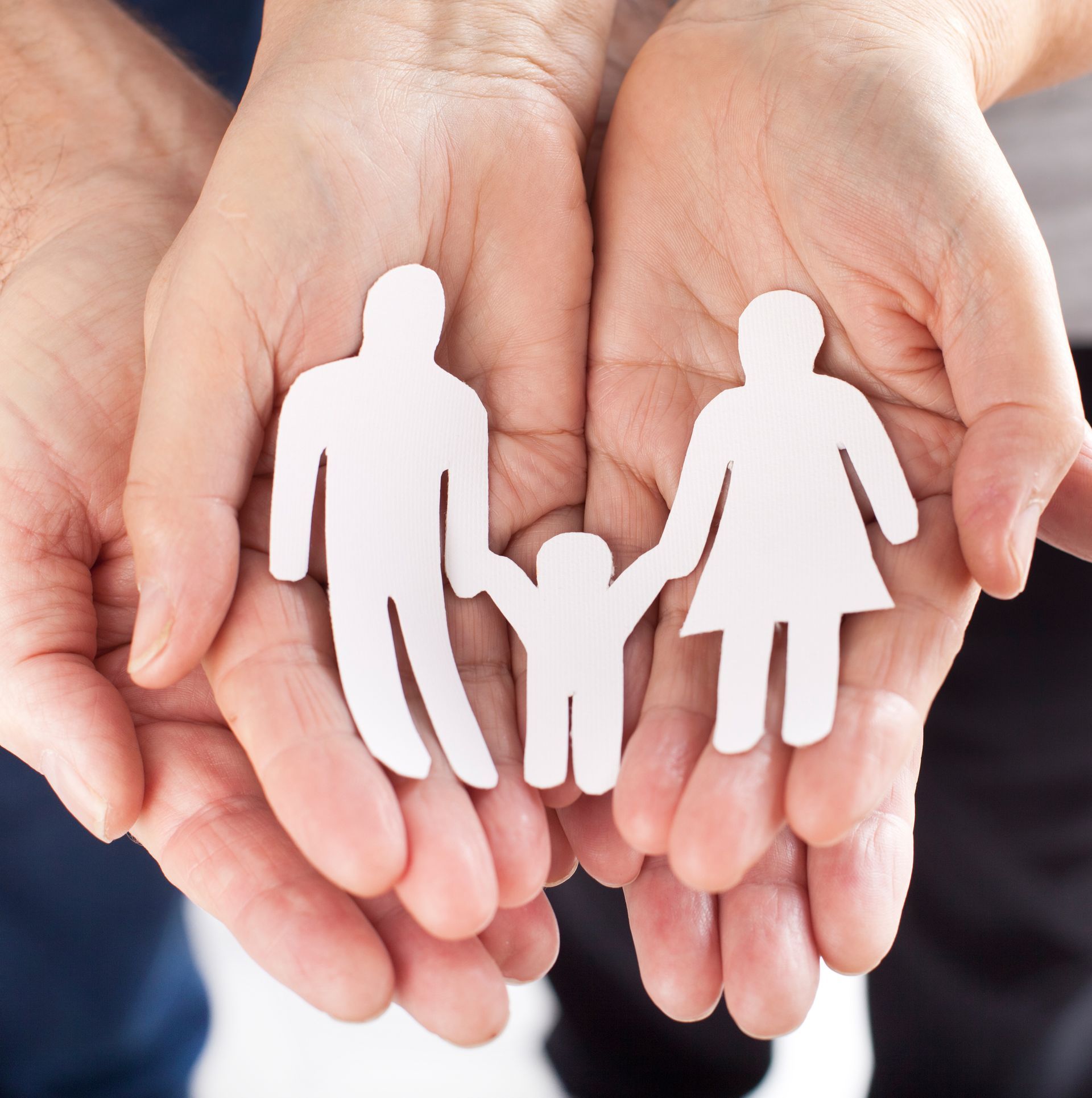 Eine Person hält eine Papierfamilie in ihren Händen