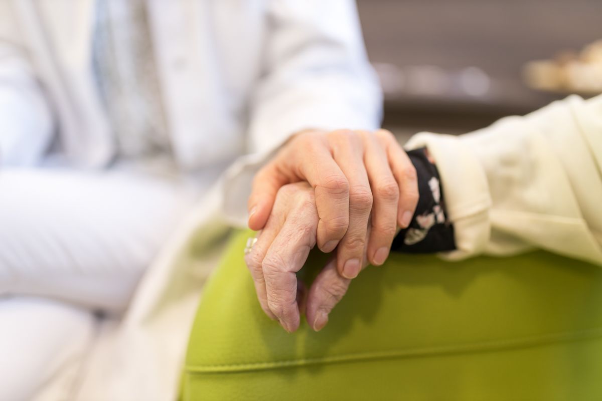 Eine Nahaufnahme einer Person, die die Hand einer anderen Person hält.