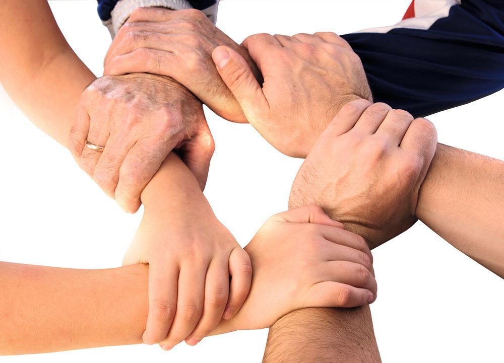 Eine Gruppe von Menschen, die ihre Hände zu einem Kreis zusammenlegen