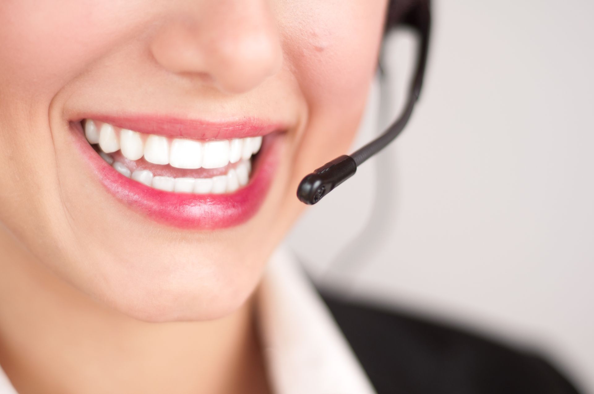 Eine Frau trägt ein Headset und lächelt.