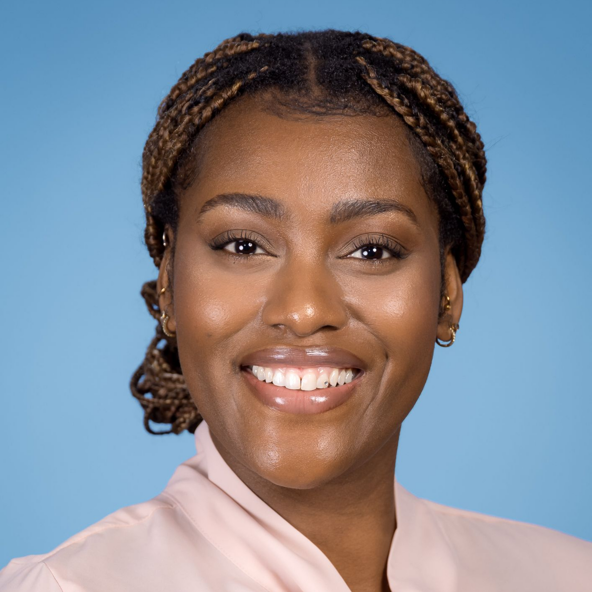 Eine Nahaufnahme des Gesichts einer Frau vor blauem Hintergrund.