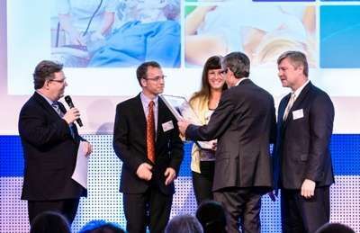 Eine Gruppe von Menschen in Anzug und Krawatte steht auf einer Bühne.