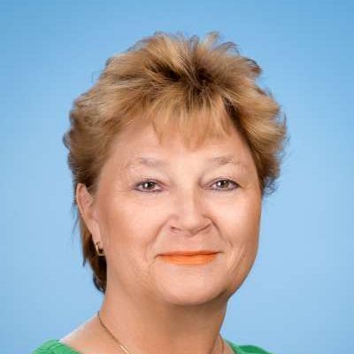 Eine Nahaufnahme des Gesichts einer Frau vor blauem Hintergrund.