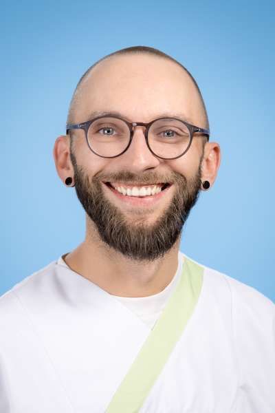 Ein Mann mit Bart und Brille lächelt in die Kamera.