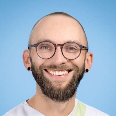 Ein Mann mit Bart und Brille lächelt in die Kamera.