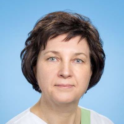 Eine Nahaufnahme des Gesichts einer Frau vor blauem Hintergrund.