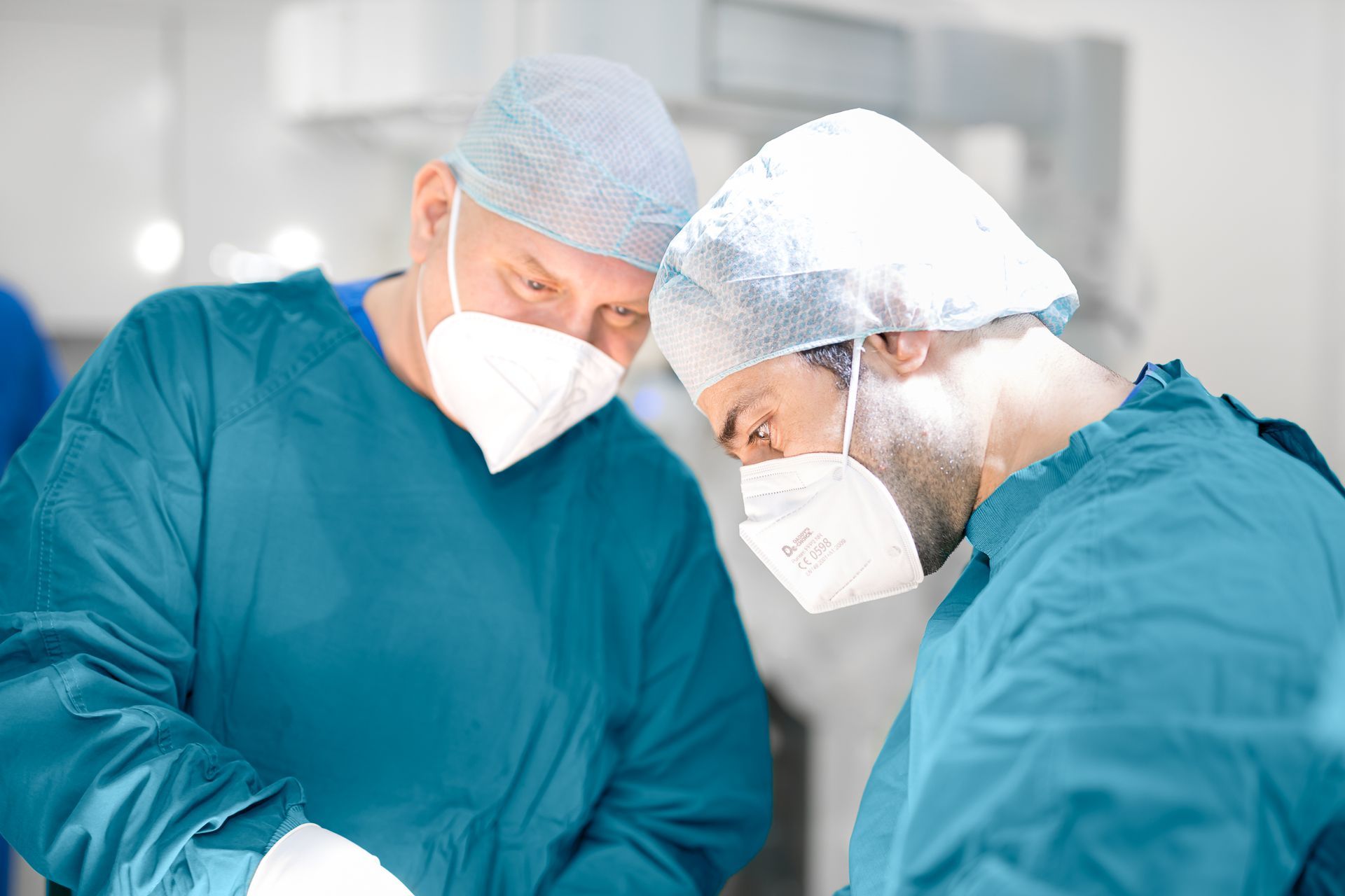 Zwei Chirurgen operieren einen Patienten in einem Operationssaal.