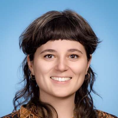 Eine Frau mit kurzen Haaren und Pony lächelt in die Kamera.