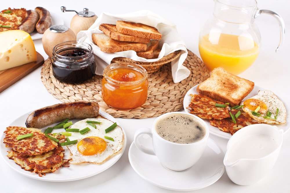 Ein Tisch mit Tellern voller Essen und einer Tasse Kaffee.