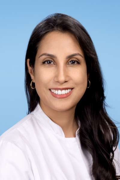 Eine Frau in einem weißen Hemd lächelt in die Kamera