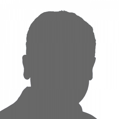 Die Frau trägt eine Brille und lächelt in die Kamera.